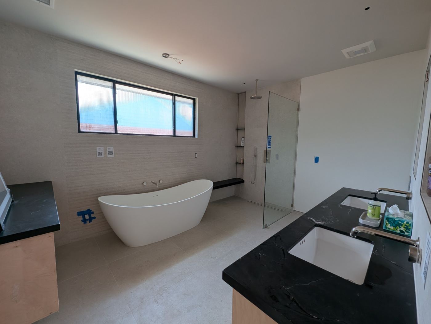 Bathroom with freestanding tub and black stone vanity